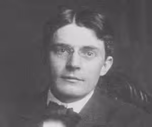 A black and white photo depicting a man in a suit and bow tie, showcasing the origins of formal attire.