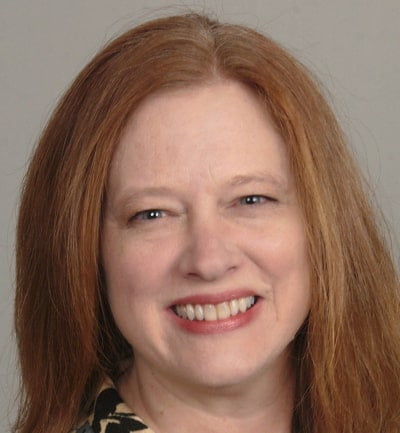 Dr. Melissa Mackal: A woman with red hair smiling for the camera for a promotional shoot.