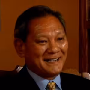 Smiling person in formal attire, indoors.
