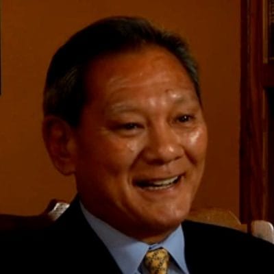 Smiling person in formal attire, indoors.