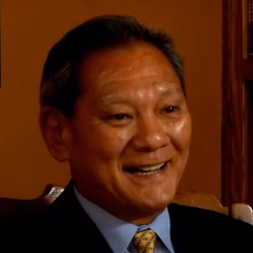 Smiling person in formal attire, indoors.