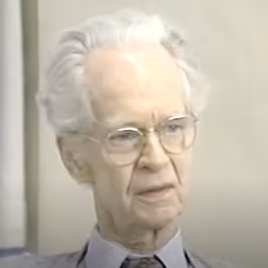 Elderly person with glasses and white hair.